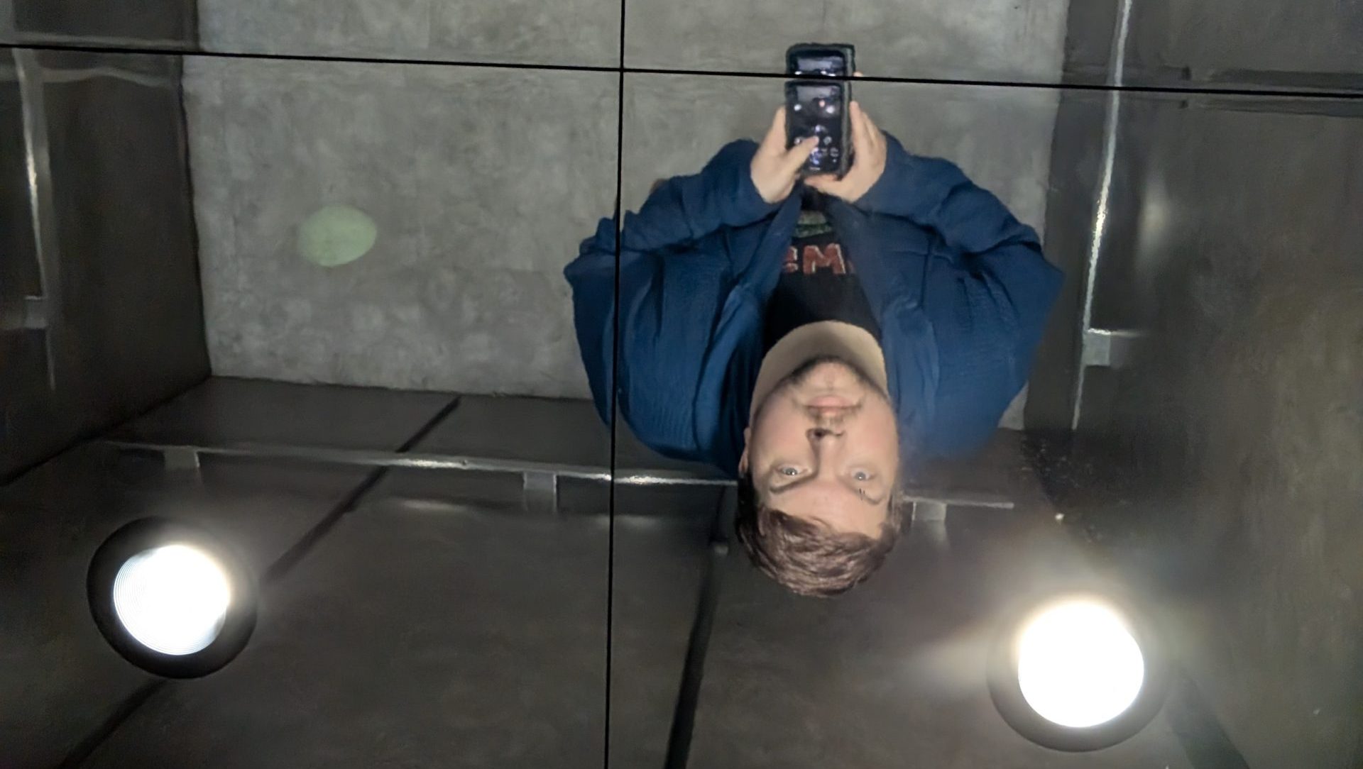 A selfie of me looking up at the mirror ceiling of an elevator.